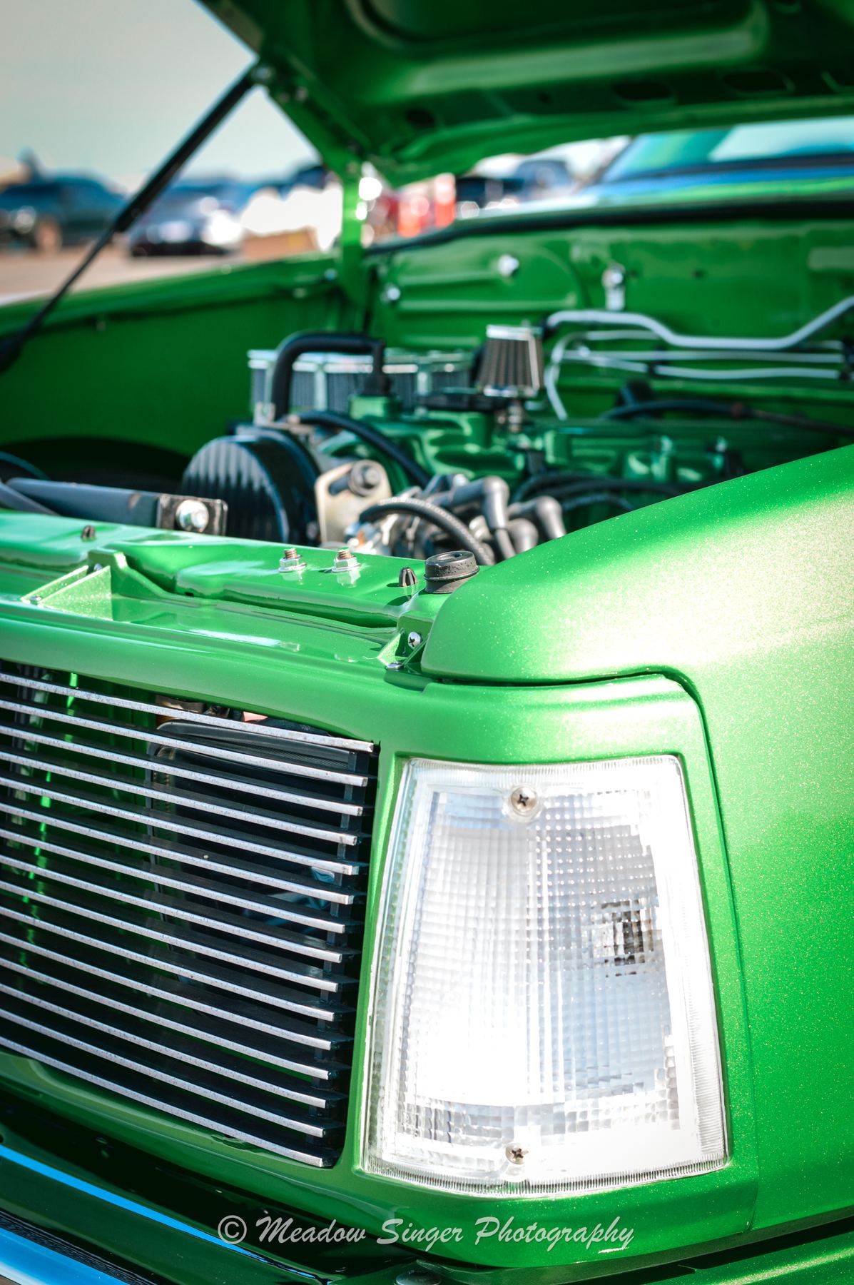 The open hood of a bright green pickup truck