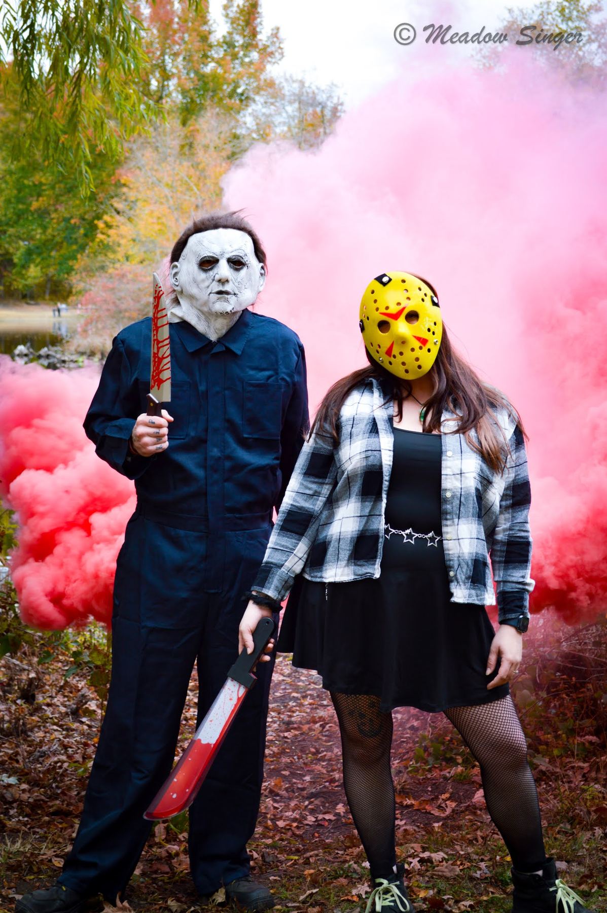 A couple dressed as horror movie villains in pink smoke