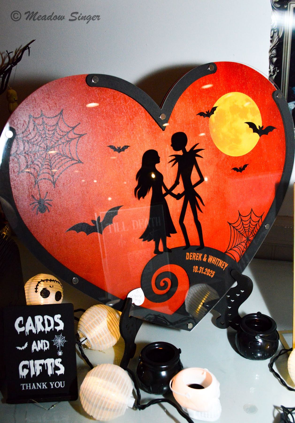 A Jack and Sally heart sign above a cards and gifts table