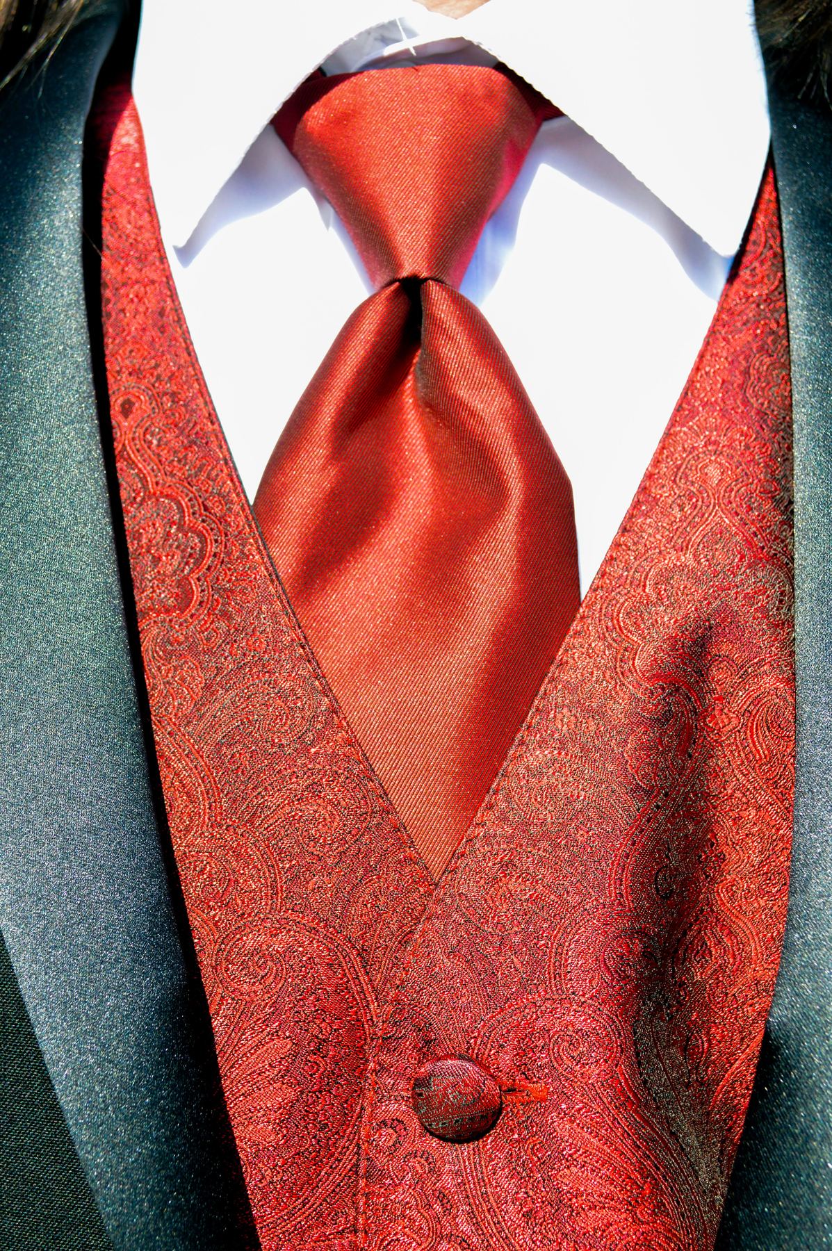 A red paisley vest and tie on a formal suit